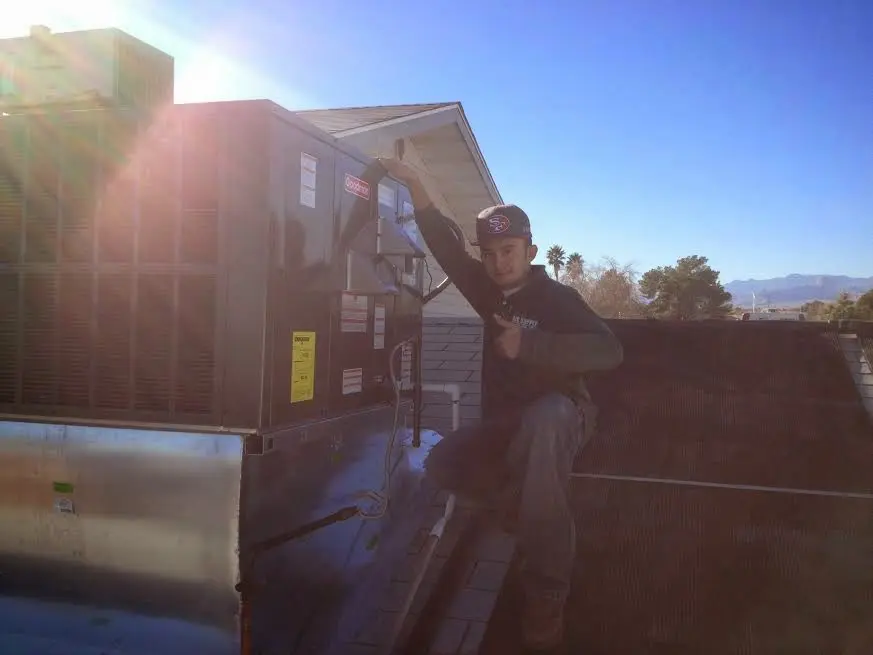 HVAC technician performing Heat Pump Repair on a rooftop unit in Humble